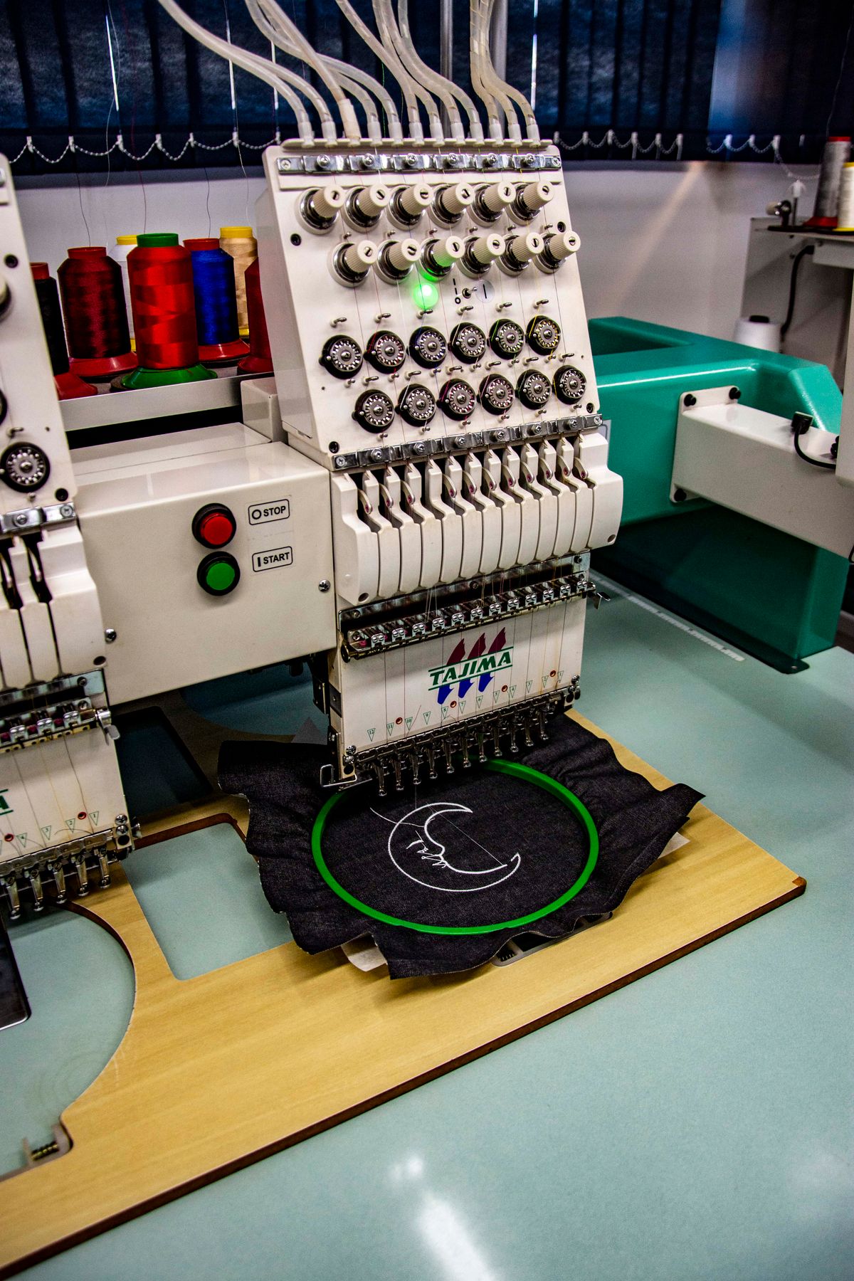 Máquina de bordado computarizado trabajando un diseño sobre tela