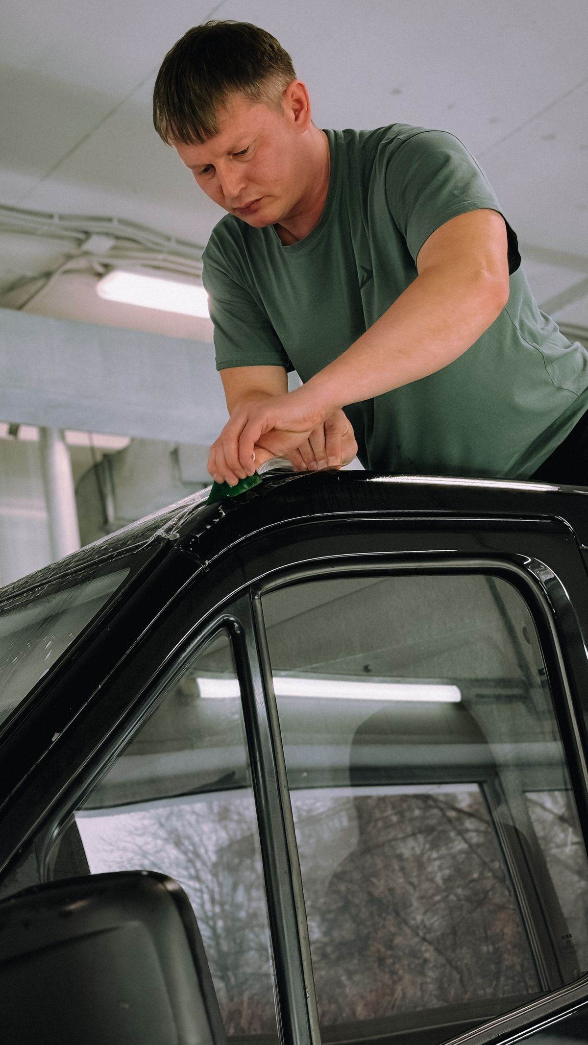 Técnico instalando polarizado en la ventana de un automóvil