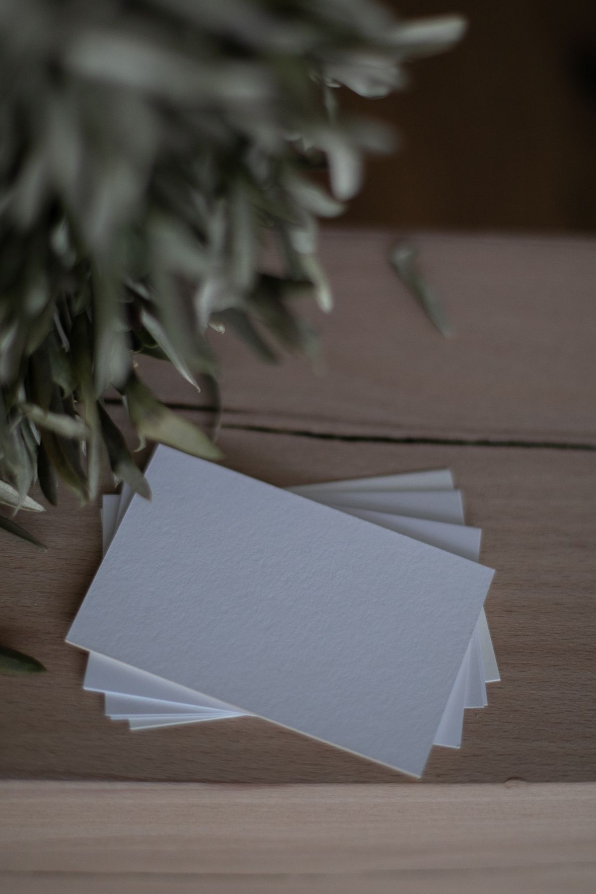 Tarjetas de presentación impresas apiladas sobre una mesa de madera